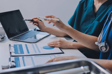 Medical team meeting analyzing blood test results in hospital laboratory. Doctors and scientists in lab coats are having a discussion about blood test result, holding test tubes and taking notes.