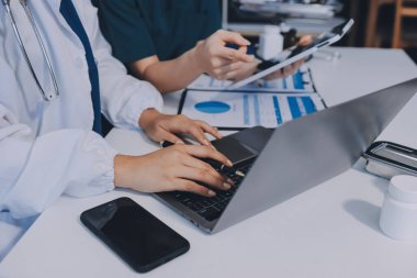 Medical team meeting analyzing blood test results in hospital laboratory. Doctors and scientists in lab coats are having a discussion about blood test result, holding test tubes and taking notes.