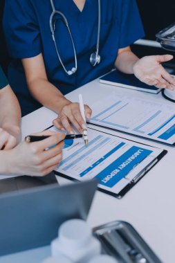 Medical team meeting analyzing blood test results in hospital laboratory. Doctors and scientists in lab coats are having a discussion about blood test result, holding test tubes and taking notes.