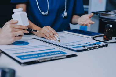 Medical team meeting analyzing blood test results in hospital laboratory. Doctors and scientists in lab coats are having a discussion about blood test result, holding test tubes and taking notes.