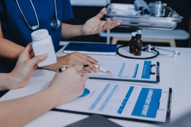 Medical team meeting analyzing blood test results in hospital laboratory. Doctors and scientists in lab coats are having a discussion about blood test result, holding test tubes and taking notes.