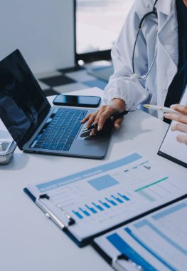 Medical team meeting analyzing blood test results in hospital laboratory. Doctors and scientists in lab coats are having a discussion about blood test result, holding test tubes and taking notes.