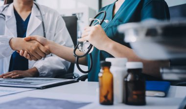 Medical team meeting analyzing blood test results in hospital laboratory. Doctors and scientists in lab coats are having a discussion about blood test result, holding test tubes and taking notes.