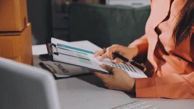 İş kadını hesap makinesi kullanıyor ve faturaları hesaplıyor.