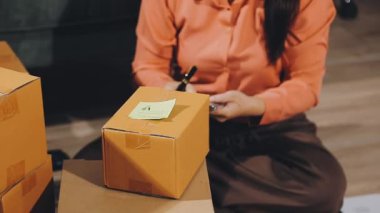 Üniformalı bir teslimatçı ve elinde karton bir paket tutan bir gömlek. servis hizmeti kavramı.