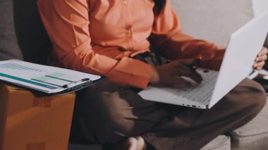 Genç Asyalı iş adamı ofiste dizüstü bilgisayarla çalışıyor.