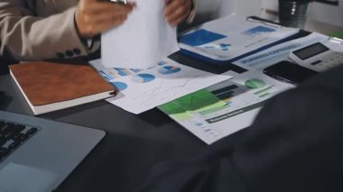 Yakın plan - Ofiste masada otururken elinde kalem ve bir belgeyle iş adamının eli.