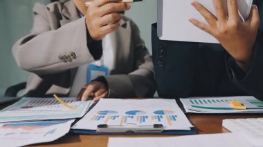 Finansal belgeler ve dizüstü bilgisayarla çalışan bir iş ekibi.