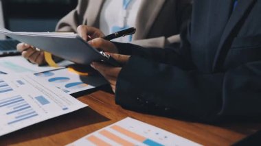 İş adamı masadaki mali veri ve grafikleri analiz ediyor.