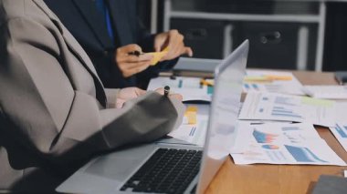 İş adamları ofiste mali tabloları ve dizüstü bilgisayarları tartışıyor. takım çalışması konsepti