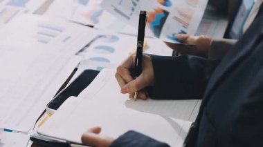 İş adamı hesap makinesiyle finansal tabloları analiz ediyor.