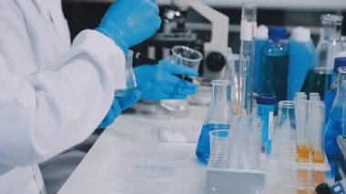 Laboratuvardaki bilim adamı kimyasal test tüpüyle çalışıyor.