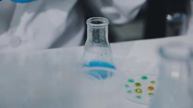 Laboratuvarda bir bardak su tutan bir bilim adamı..