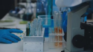 Laboratuvarda deney tüpleriyle tüpü tutan bilim adamı.