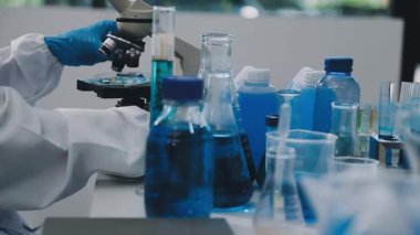 Laboratuvarda çalışan bilim adamı. Mikroskop ve test tüpüyle çalışan bilim adamı.