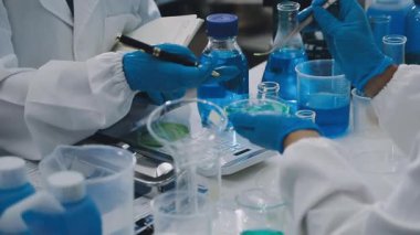 Mavi sıvılı laboratuvar bardakları.