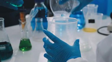 Laboratuvarda kimyasal şişesi olan bir bilim adamı.