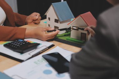 Ekip toplantısında, ESG konu sunumu için dizüstü bilgisayar kullanan Asyalı kadın, çok ırklı iş adamlarından oluşan genç bir gruba liderlik ediyor. Sürdürülebilir iş uygulaması, insanlar ev konseptinde çalışıyor