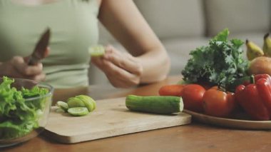 Kadın mutfakta salata hazırlıyor.