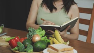 Mutfakta yemek ve salata getiren bir kadın var.