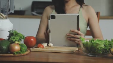 Genç bir kadın mutfakta yemek pişiriyor.