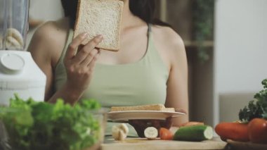 Mutfakta ekmeği tutan kadın.