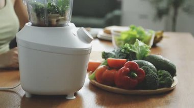 Kadın mutfakta taze sebze püresi pişiriyor.