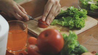 Mutfakta sebze doğrayan genç bir kadın.