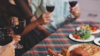 Arkadaşlar şarap kadehiyle yemek yiyorlar..