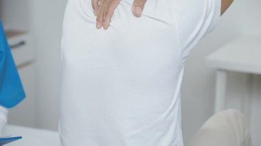 Hastane ofisinde elinde bir hasta tutan bir doktor.