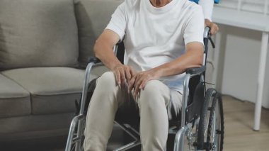 Koltuk değnekli Asyalı adam.