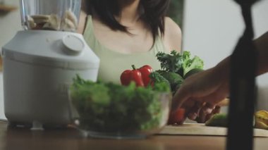 Kadın mutfakta sebze salatası hazırlıyor.