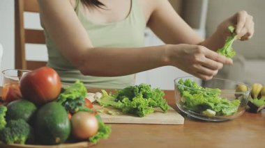 Kadın mutfakta salata pişiriyor..