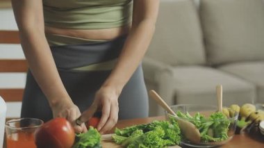 Kadın mutfakta taze salata pişiriyor.