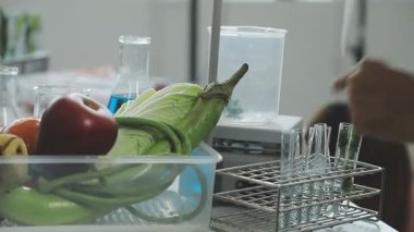 Erkek eli mutfak tezgahındaki cam kabın içine taze yeşil sebzeler koyuyor..