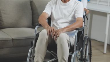 Koltuk değnekli Asyalı genç adam.