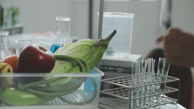 El plastik bir şişe ve bir bardak su tutuyor.