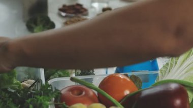 Genç bir kadın mutfakta yemek pişiriyor.