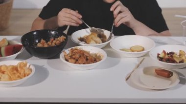 Kadın tavuk göğsü ve patates kızartması yiyor.