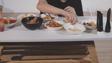 Lezzetli ve lezzetli yemeklerle masada oturan bir kadın.