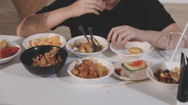 Adam lezzetli tavuk kanatları yiyor.