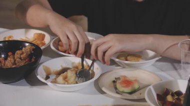 Asyalı kadın yemek çubuğuyla suşi yiyor.