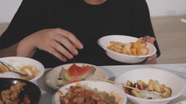 Kadın mutfakta Asya tavuğu ve sebze yiyor.