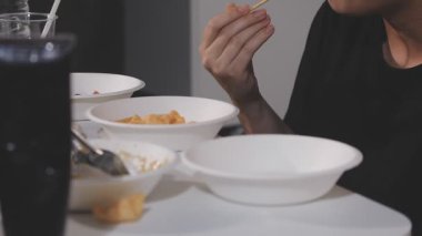 Adam çubukla erişte yiyor.