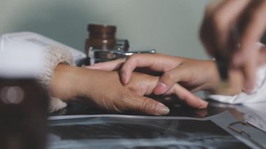 Kadın eline oje sürüyor.