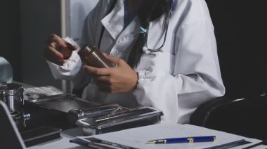 Kadın doktor iş yerindeki panoya yazı yazıyor.