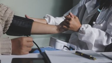 Doktor hastaların ellerini steteskopla kontrol ediyor..