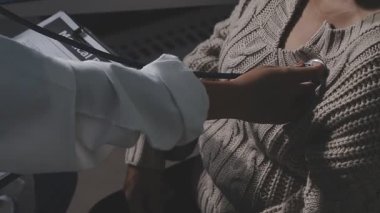 Stetoskop tutan bir kadın doktorun yakın çekimi.