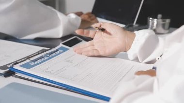 Doktor ofisteki hastanın tansiyonunu ölçüyor.