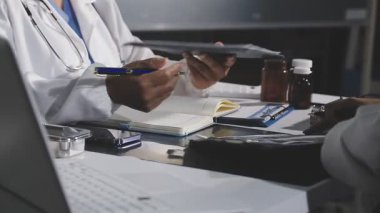 Doktor hastane ofisinde reçete yazıyor.